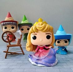 some little figurines that are sitting on the floor next to each other and one is wearing a princess dress