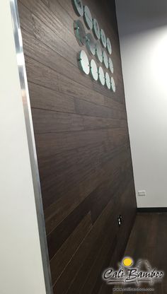 an office hallway with wood paneling and round clocks mounted on the wall above it