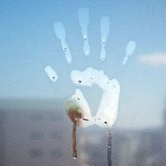 a hand print on a window with the city in the background