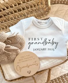 a baby's first birthday shirt and mitts in a wicker basket