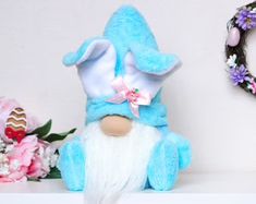 a blue stuffed animal sitting on top of a shelf next to a wreath and flowers