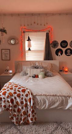 a white bed sitting in a bedroom next to a window with red lights on it