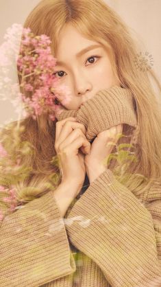 a woman with long blonde hair holding flowers