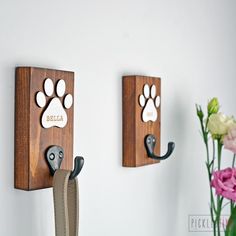 two wooden wall hooks with dog paw prints on them