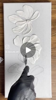 someone is drawing flowers on a canvas