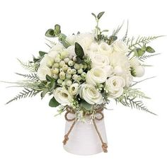 a white vase filled with flowers and greenery