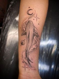 a tattoo on the arm of a woman with a dolphin and sun in it's center