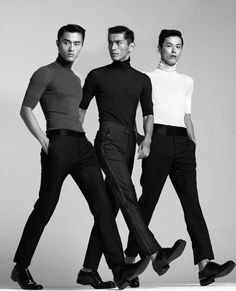 three men in black and white standing next to each other with their hands on their hipss