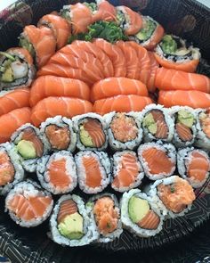 a platter filled with sushi and cucumbers