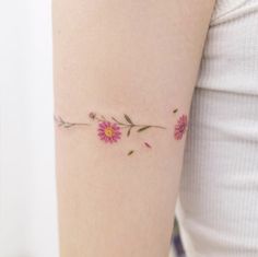 a woman's arm with pink flowers and leaves on the left side of her body