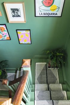 an overhead view of some stairs with pictures on the wall