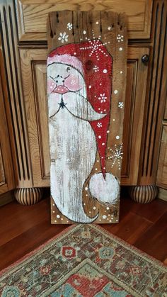 a wooden sign with a santa clause on it sitting next to a rug in a kitchen