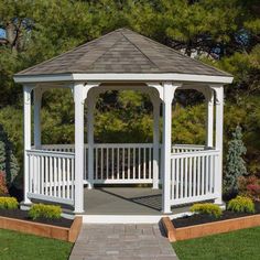 a white gazebo sitting on top of a lush green field