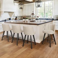 a kitchen island with four stools in front of it