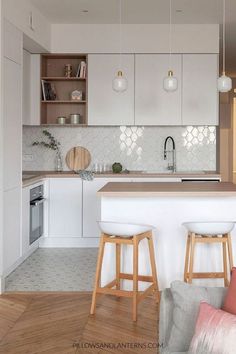 a kitchen with two stools in front of an island