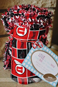 a red and black gift wrapped in paper with a tag on it's side