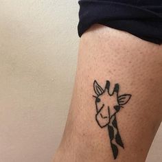 a small giraffe tattoo on the leg of a woman's calfe