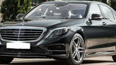 a black mercedes s - class parked in front of a building