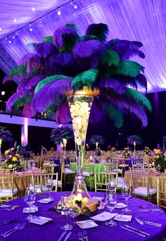 an image of a table setting with purple and green decorations on it for a wedding