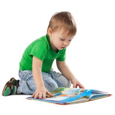 a little boy sitting on the floor reading a book