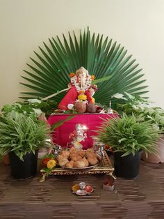 there is a small gandap surrounded by potted plants and other decorations on the table