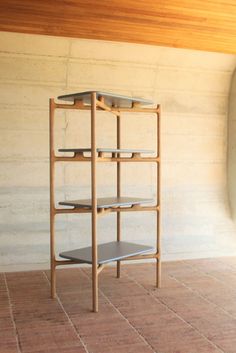 a wooden shelf sitting on top of a brick floor next to a wall and window