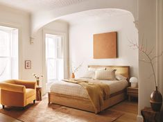 a bedroom with white walls and wooden floors