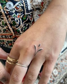 a woman's hand with a small tattoo on it