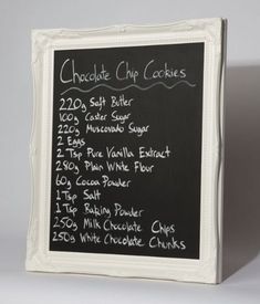 a chalkboard menu board with writing on the front and bottom, attached to a white frame