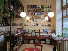 a room filled with lots of books on the wall next to a table and chairs