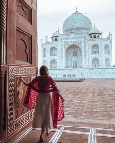 a woman is standing in front of the tajwa, which has been built into an