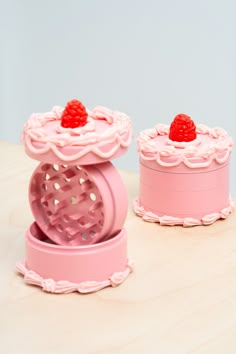 two small pink cakes with raspberries on top