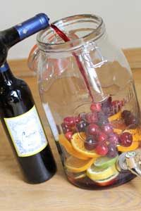 a bottle of wine is being filled with fruit