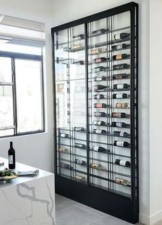 a wine rack in the corner of a room with a marble counter top and white walls