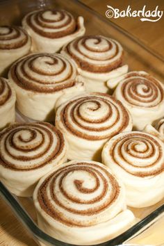 cinnamon rolls in a glass baking dish on a wooden table