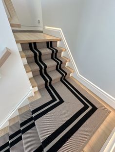 the stairs are lined with black and white rugs