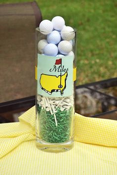 a glass filled with golf balls sitting on top of a table