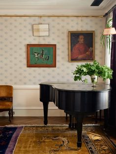 a living room with a grand piano and paintings on the wall