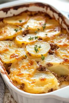 a casserole dish with potatoes, meat and parmesan cheese on top