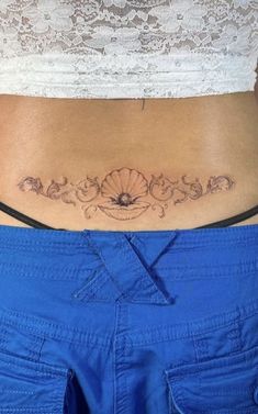 a woman's stomach with a tattoo on her lower back and the bottom part of her belly