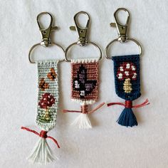 three crocheted key fobs hanging from metal hooks