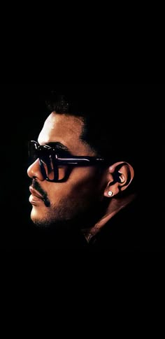 a man wearing sunglasses and piercings in the dark