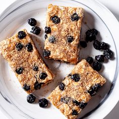 three pieces of granola topped with blueberries on a plate