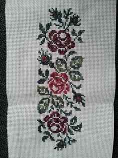 a cross - stitched piece of cloth with flowers on it