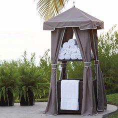 a gazebo with towels on it in the middle of a sidewalk next to trees