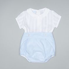 Brand: Artesania Granlei Reference: 124-266 Color: White- Blue Materials: 100% cotton, 100% polyester Description: This blue and white suit for baby boys is by Artesania Granlei. The short-sleeved top is made from soft cotton with a subtle striped pattern and tonal lattice embroidery. It has a Peter Pan collar and fastens with buttons on the back for a neat finish. Made from tulle-covered poplin with a lightweight lining, the bloomer shorts have a partially elasticated waistband, pleated detaili White Cotton Short Sleeve Sets, Light Blue Cotton Short Sleeve Sets, Light Blue Short Sleeve Sets For Summer, Light Blue Short Sleeve Summer Sets, Spring Baptism Short Sleeve Sets, Light Blue Fitted Short Sleeve Sets, Cotton Baptism Sets, Classic Short Sleeve Sets For Spring, Light Blue Short Sleeve Sets For Spring