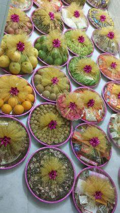 many different types of fruits and vegetables are on the table with plastic plates that have flowers in them