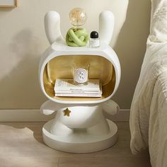 a white toilet sitting on top of a wooden floor next to a bed and nightstand