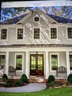 a house with white siding and windows on the front door is seen on an iphone screen