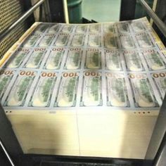 stacks of money sitting on top of each other in front of a conveyor belt